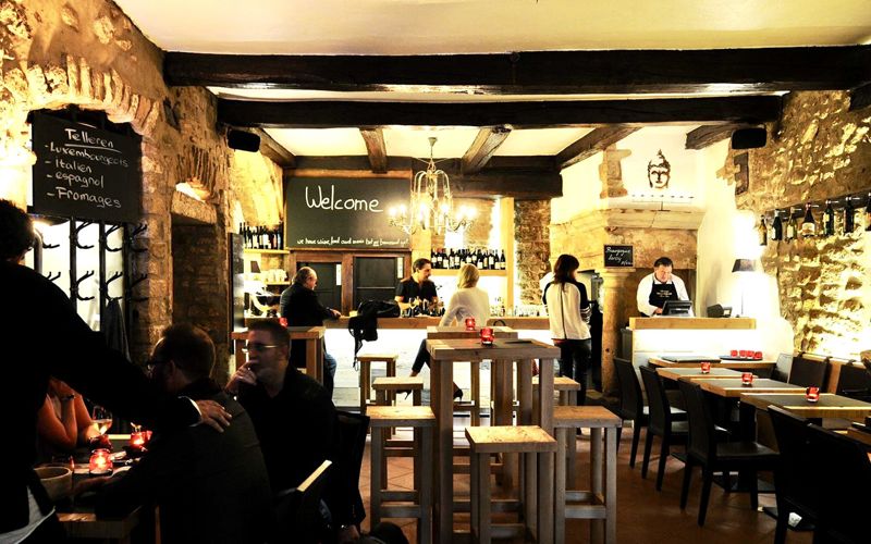 Inside Dipso: vaulted stone walls, wooden beams and the bar ready for after work